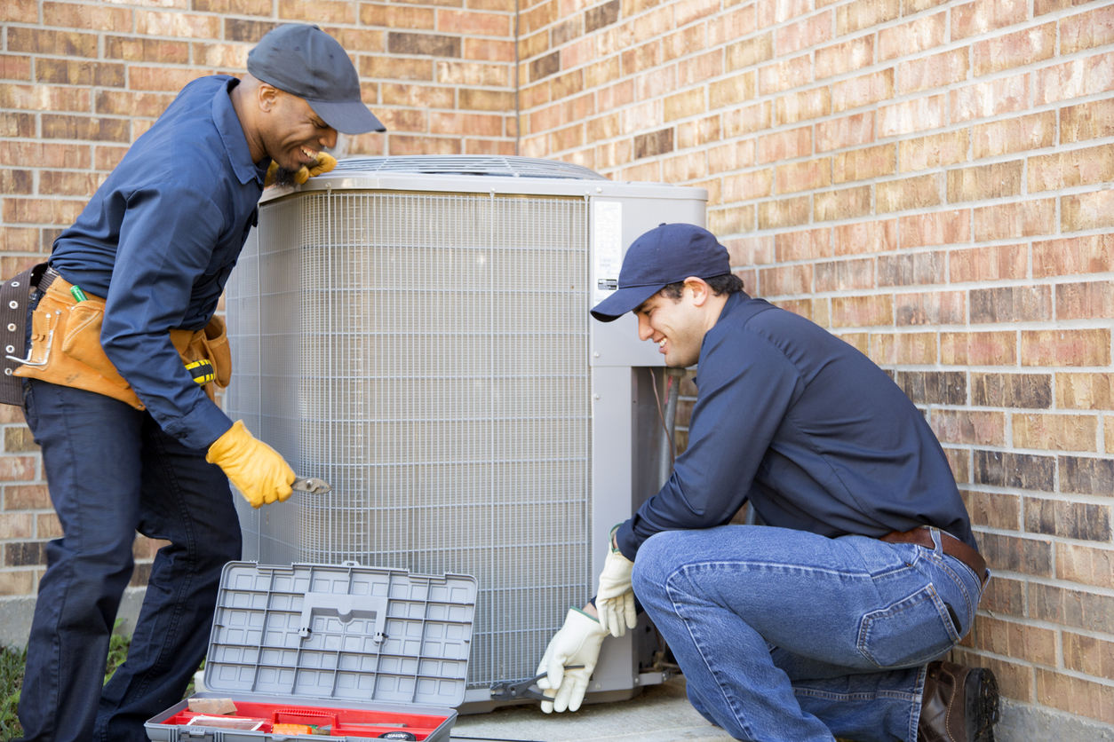 Multi ethnic team of blue collar air conditioner repairmen at work